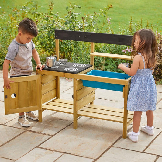 Niños jugando con cocinita de madera ecológica al aire libre, juguetes ecológicos para niños