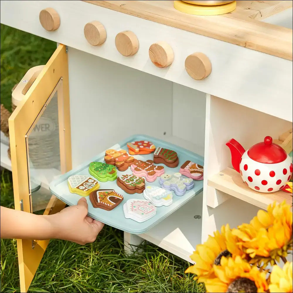 Cocina gigante para exterior de madera con horno y accesorios de juego infantil en patio verde