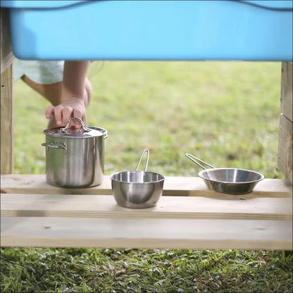 Juego de ollas y sartenes de acero inoxidable sobre una superficie de madera con Exterior Chef Junior