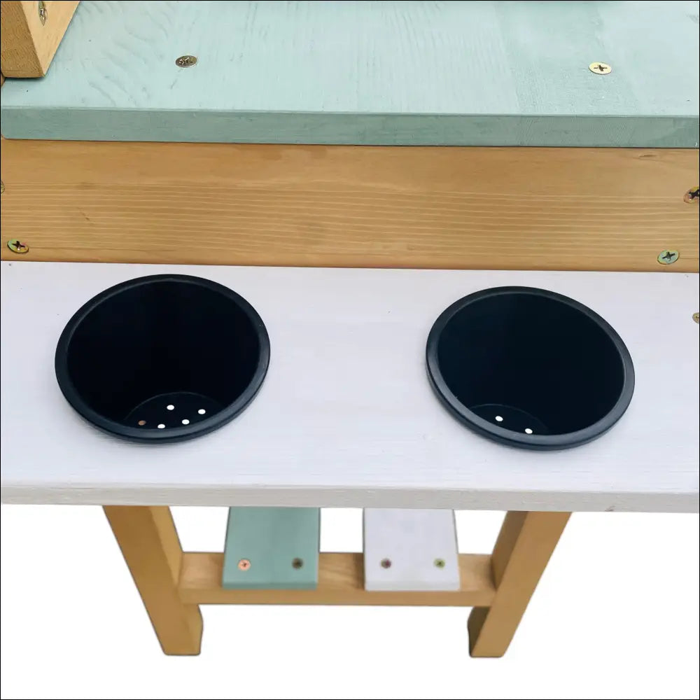Mesa de trabajo de madera con agujeros circulares en la Cocinita Exterior AXI